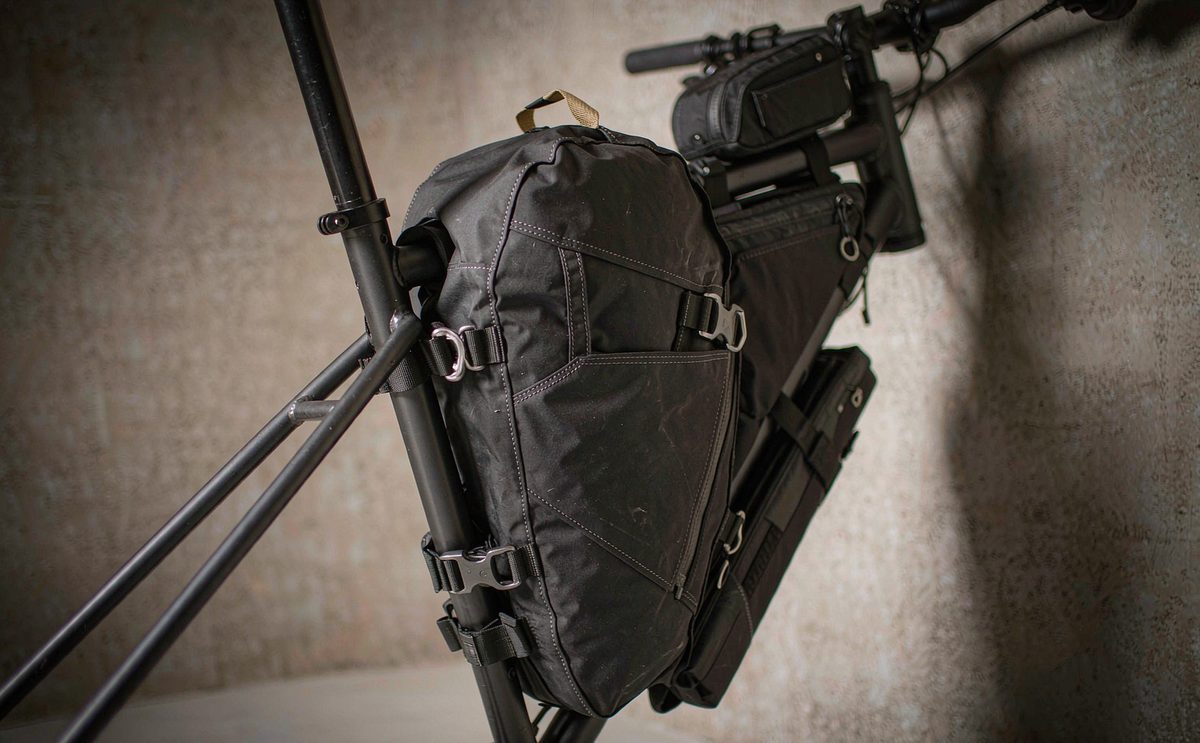 A black frame bag strapped inside the triangle of a gravel bicycle