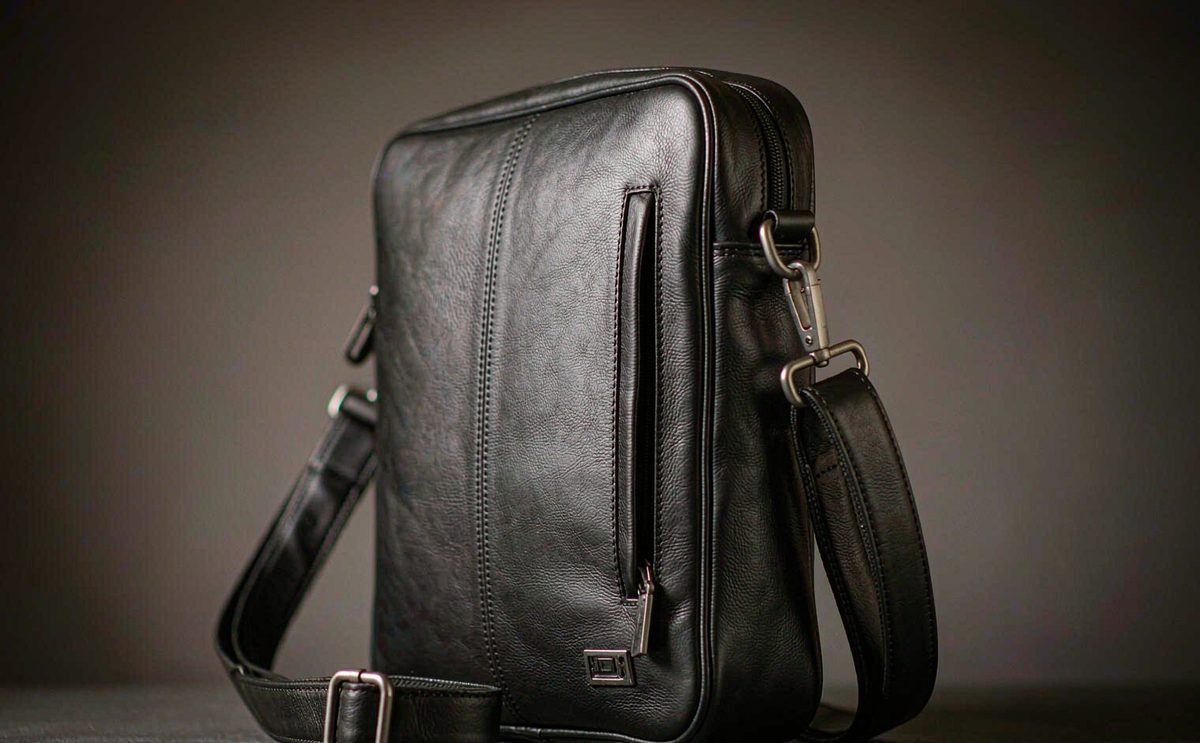 A slim black leather briefcase with matte hardware and a shoulder strap