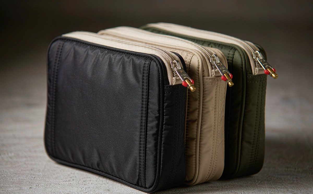 Three zippered pouches in black, sand and olive nested by size