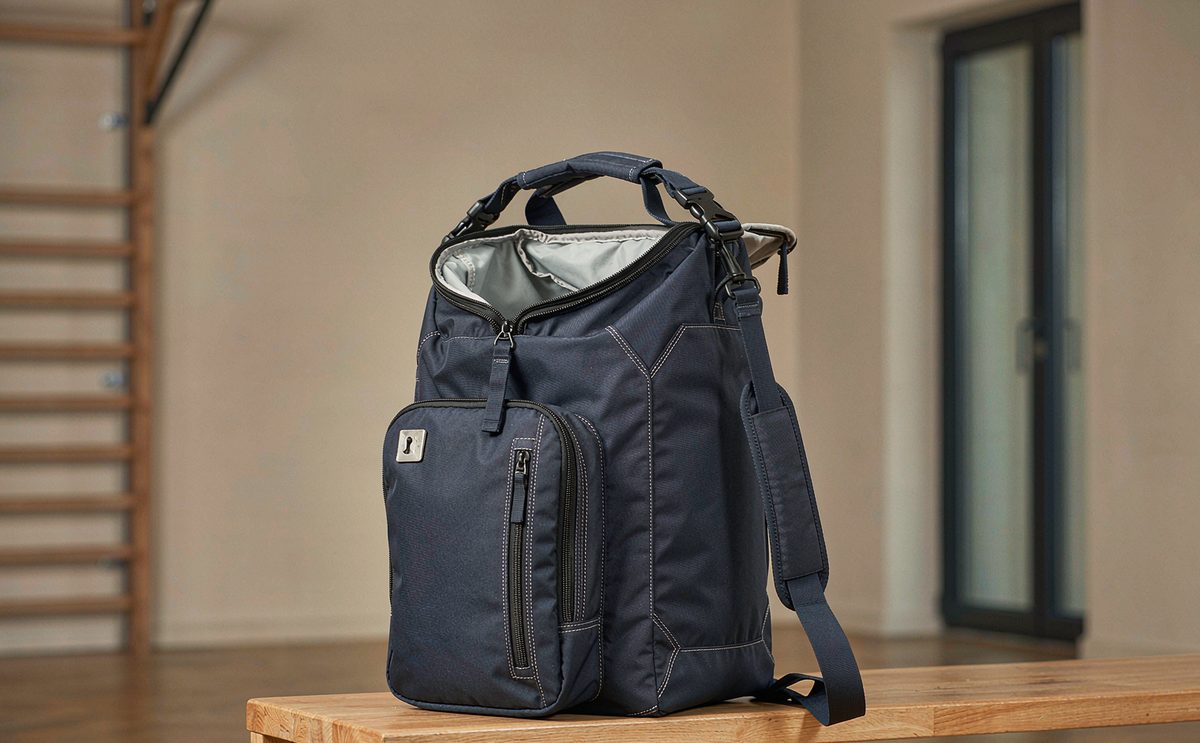 Custom sports and team bag prototypes with vented side panels, mesh shoe tunnel, wet compartment lining and webbing handles under review on a sampling bench