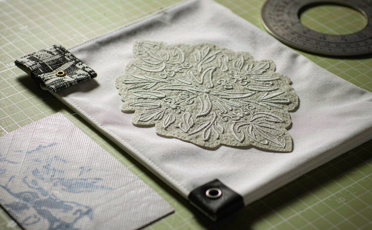 Embroidered, screen-printed and woven-label samples laid flat on a cutting mat